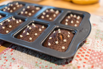 Brownie chocolate cake  with nut on hot tray plate on the wood table.