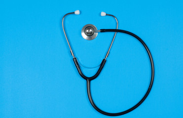 Medical stethoscope on blue background.
