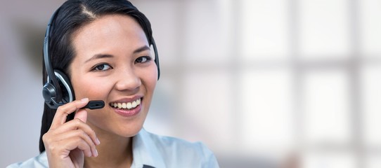 Composite image of smiling businesswoman using headset