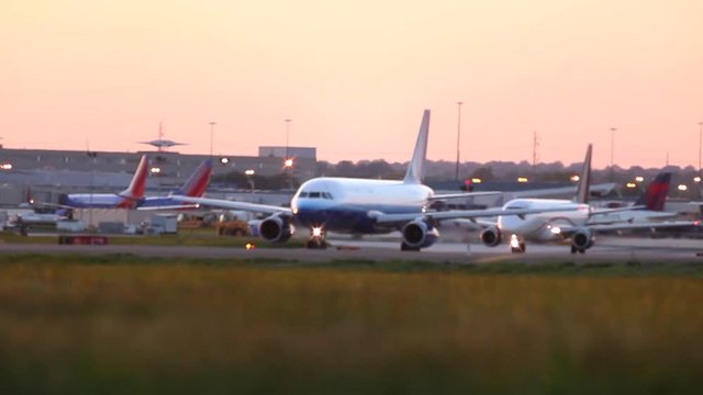 Defocused airplane taxiing on a runway at sunrise