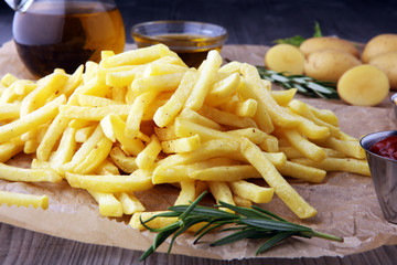 french fries, chips on wooden background with salt