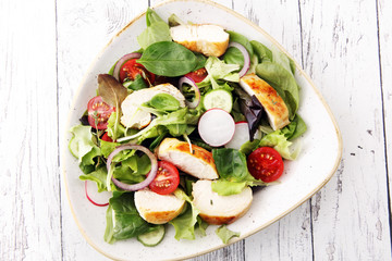 Chicken salad with leaf vegetables and cherry tomatoes.