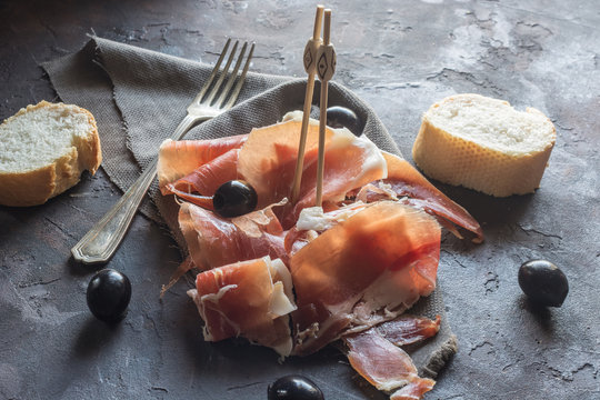 Portion of Ib&eacute;ric ham, along with bread and olives.