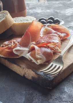 Portion of Ib&eacute;ric ham, along with bread and olives.