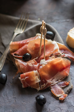 Portion of Ib&eacute;ric ham, along with bread and olives.