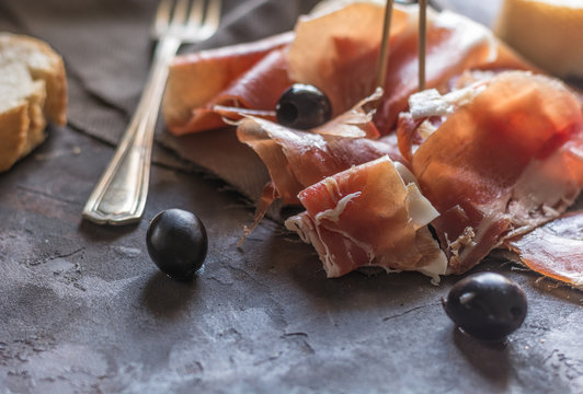Portion of Ib&eacute;ric ham, along with bread and olives.
