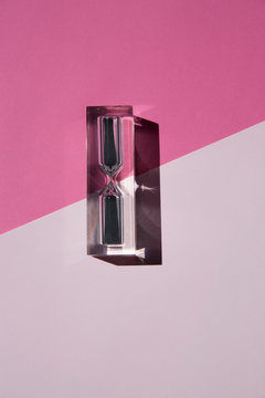 Hourglass on a pink background