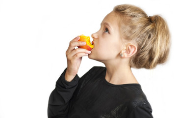 The blonde girl eats a delicious peach and looks upstairs