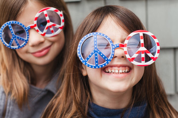 Silly sisters wearing patriotic peace sign glasses, United States of America