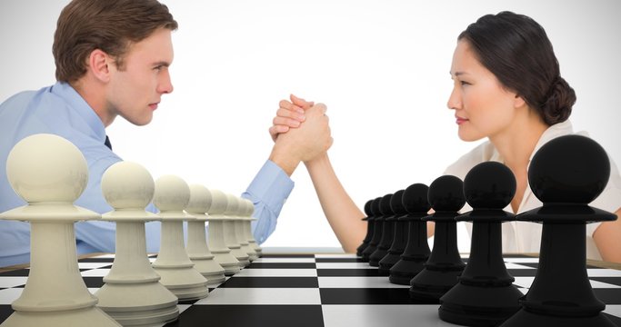 Composite image of business couple arm wrestling at desk