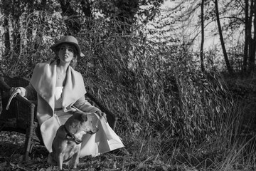 beautiful woman in a coat hat and a white dress for a walk in an autumn park or forest.