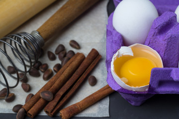 eggs in the tray, accessories for baking: whisk, rolling pin, paper, pine nuts close-up.