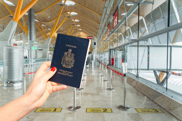 Hand holding a Canadian passport just before boarding. Three different lines, group 1, group 2 and...