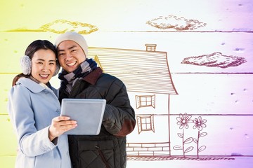 Composite image of portrait of happy couple using digital tablet
