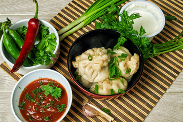 Georgian dumplings Khinkali with meat, herbs and tomato sauce . National cuisine