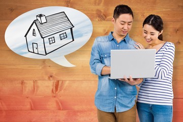 Composite image of happy couple using laptop