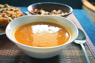 White dish with pumpkin soup-puree close-up. Selective focus.