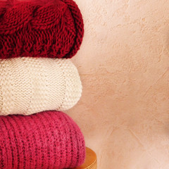 A pile of three knitted sweaters. Warm winter clothing