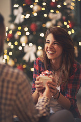 Smiling girl takes Christmas gift from her boyfriend