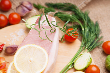 Raw pork on cutting board and vegetables 