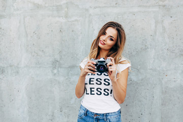 Naklejka na ściany i meble Stylish woman photographer in white T-shirt with word 
