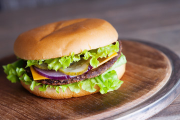Delicious hamburger on a wooden cutting board 