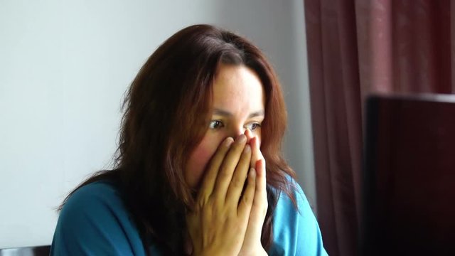 beautiful young emotional woman in front of computer watching awful thing with horrible scared face bad news information h