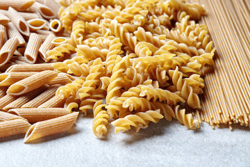 Various types of pasta on stone table