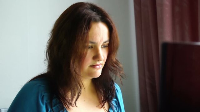 beautiful young emotional woman in front of computer watching awful thing with horrible scared face bad news information