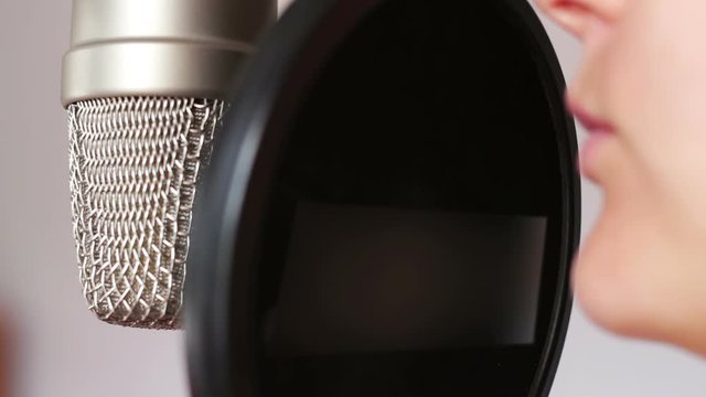 Beautiful girl gives an interview in studio microphone