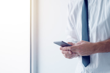 Businessman texting on mobile phone