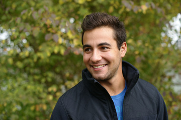 junger Mann, teenager l&auml;chelnd, blick zur seite, im gr&uuml;nen