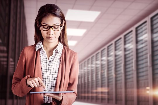 Composite image of businesswoman with eyeglasses using a tablet