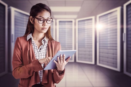 Composite image of businesswoman with eyeglasses using a tablet
