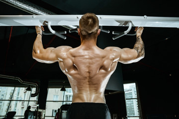 Handsome model young man training back in gym