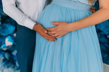  guy and girl husband and wife cling to the belly of a pregnant woman