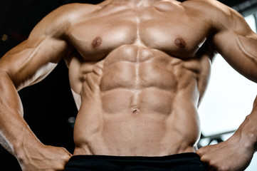Fototapeta na wymiar Handsome model young man training abs in gym