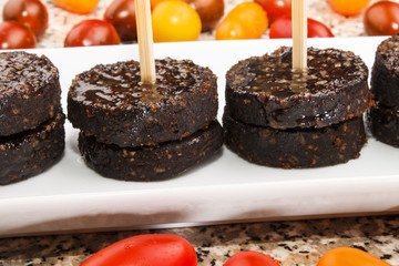 irish black pudding as party snack on a white plate