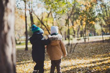 two baby boy playing in autumn Park,run and jump