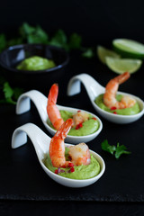 Delicate avocado soup with shrimps, lime and cilantro.