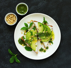 Sandwich with avocado, goat cheese and arugula. View from above.