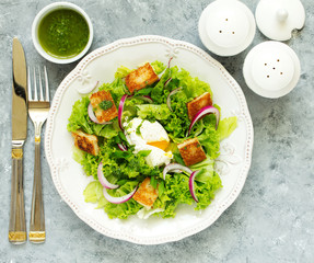 Spring salad with poached egg and crispy croutons. View from above.