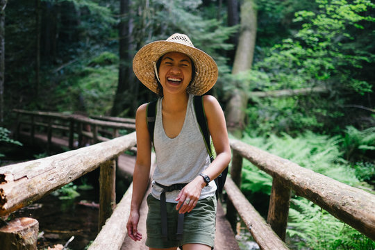 Woman laughing while crossing a bridge on a hike