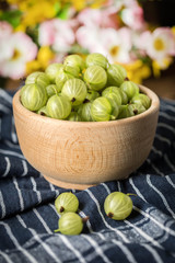 Fresh gooseberry in a wooden bowl.