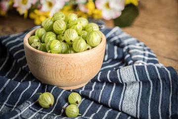 Fresh gooseberry in a wooden bowl.