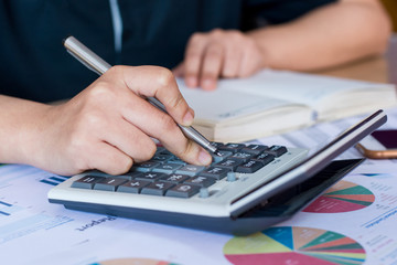 woman hand using calculator and writing make note with calculate