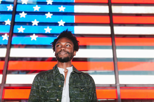Young Trendy Afro American Man with a Digital USA Flag Backwards in Times Square, New York