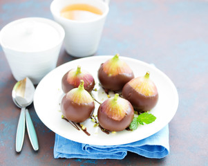 Dessert, fresh figs in chocolate with pistachios.