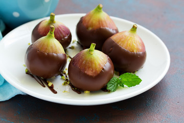 Dessert, fresh figs in chocolate with pistachios.