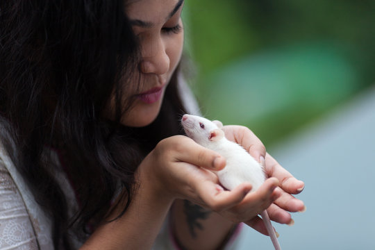 Close up shot of a girl with her pet white mouse